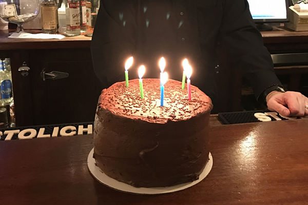 lit birthday cake with chocolate frosting